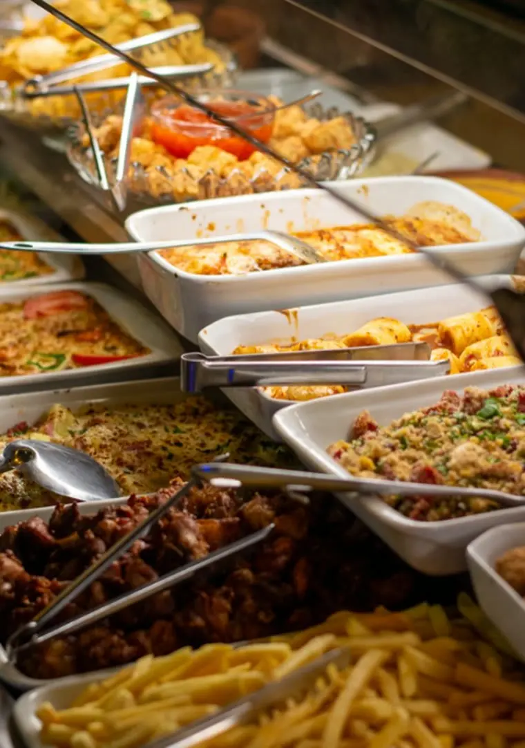Bufê da casa com travessas quentes, saladas e frituras